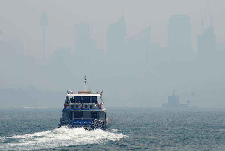 Balsa navega na baía de Sydney diante de prédios cobertos por fumaça
05/12/2019
REUTERS/Stephen Coates