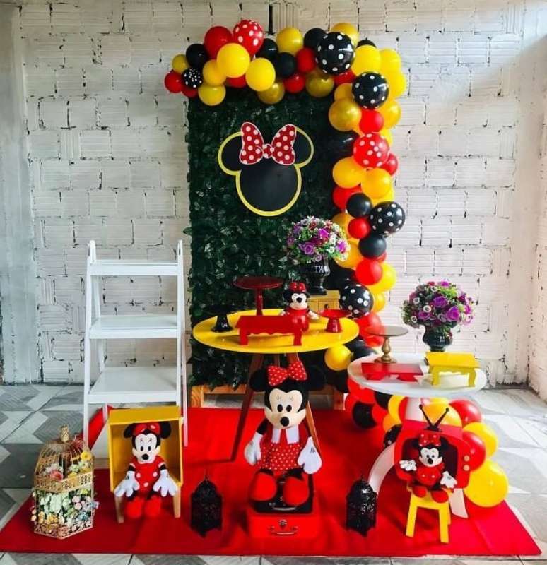 102 – Festa da Minnie simples com estante escada e painel com plantas artificiais. Fonte: Pinterest