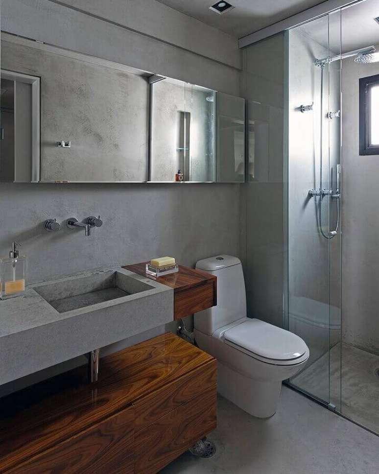 10. Banheiro moderno decorado com parede cinza de cimento queimado e armário de madeira – Foto: Diego Revollo