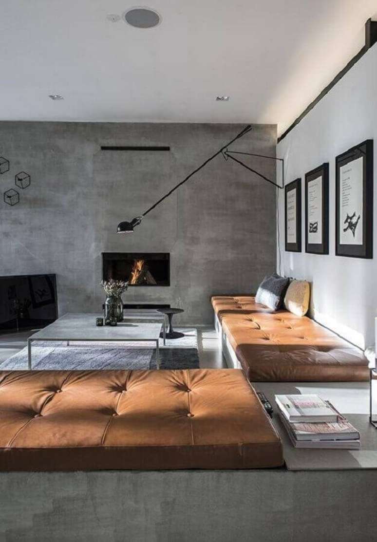 18. Decoração moderna para sala ampla com parede cinza de cimento queimado e sofá de couro – Foto: HappyModern