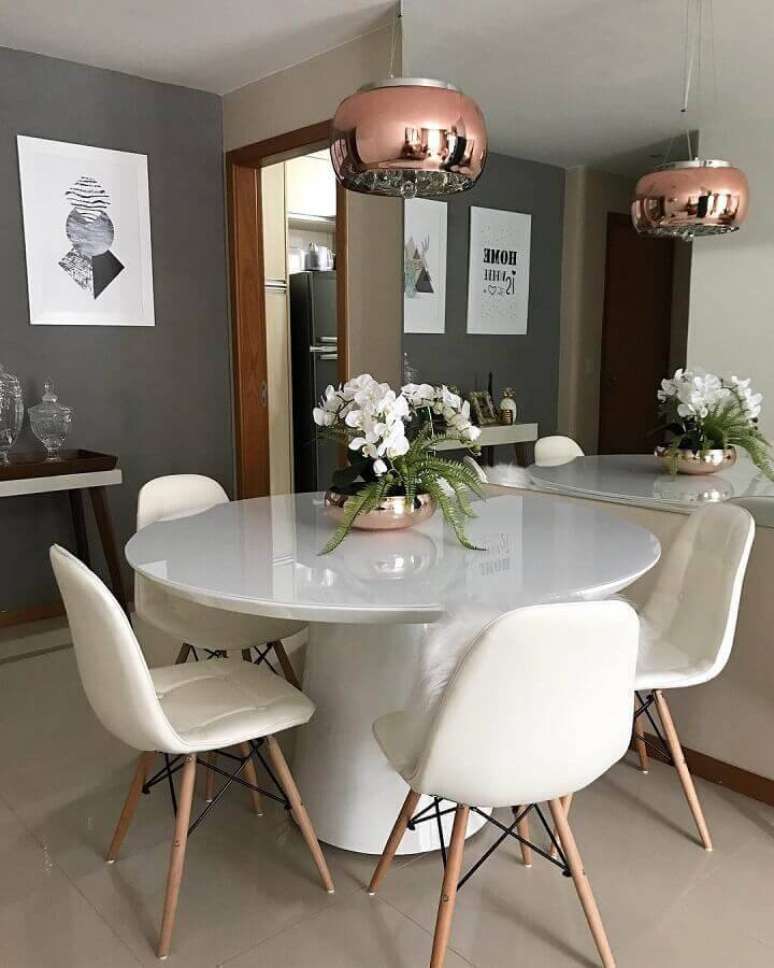 38. Decoração para sala de jantar moderna com parede cinza e mesa redonda branca – Foto: Karina Avelino