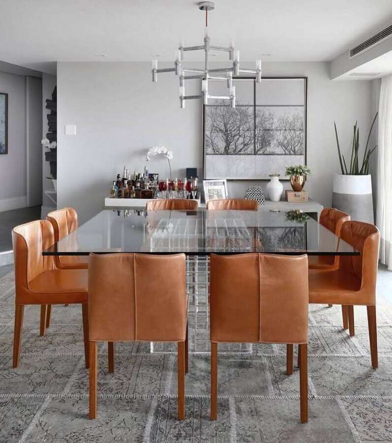54. Sala de jantar moderna decorada com parece cinza clara e mesa de vidro quadrada – Foto: Dudi Duarte
