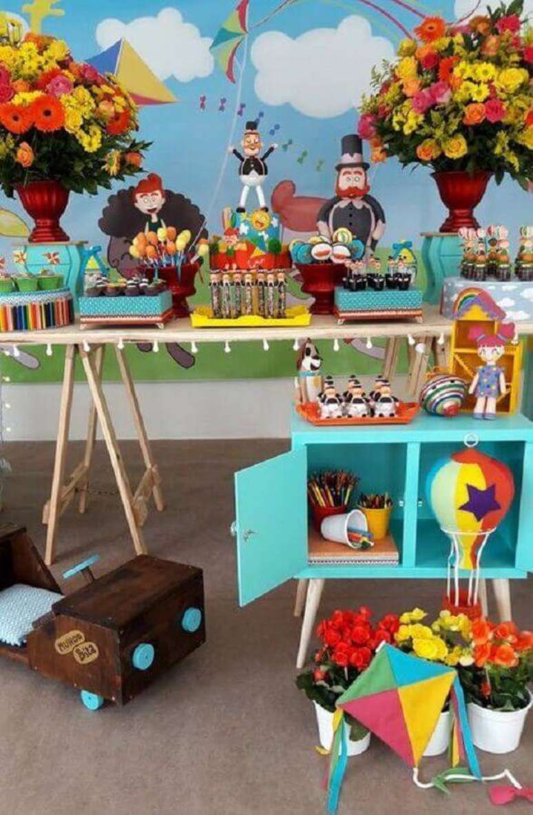 22. Linda decoração festa Mundo Bita com arranjos de flores e móvel colorido – Foto: Fazer em Casa