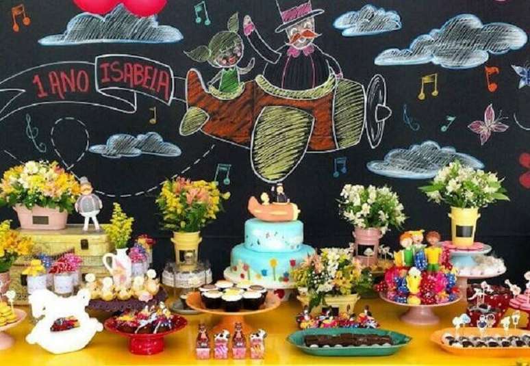 23. Decoração festa Mundo Bita simples decorada com parede de lousa e pequenos arranjos de flores – Foto: Festas biz