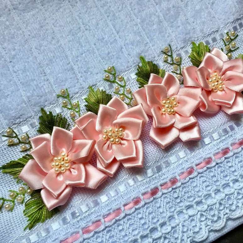 23. Flor de fita de cetim rosa na toalha azul com folhas verdes – Via: Elo7