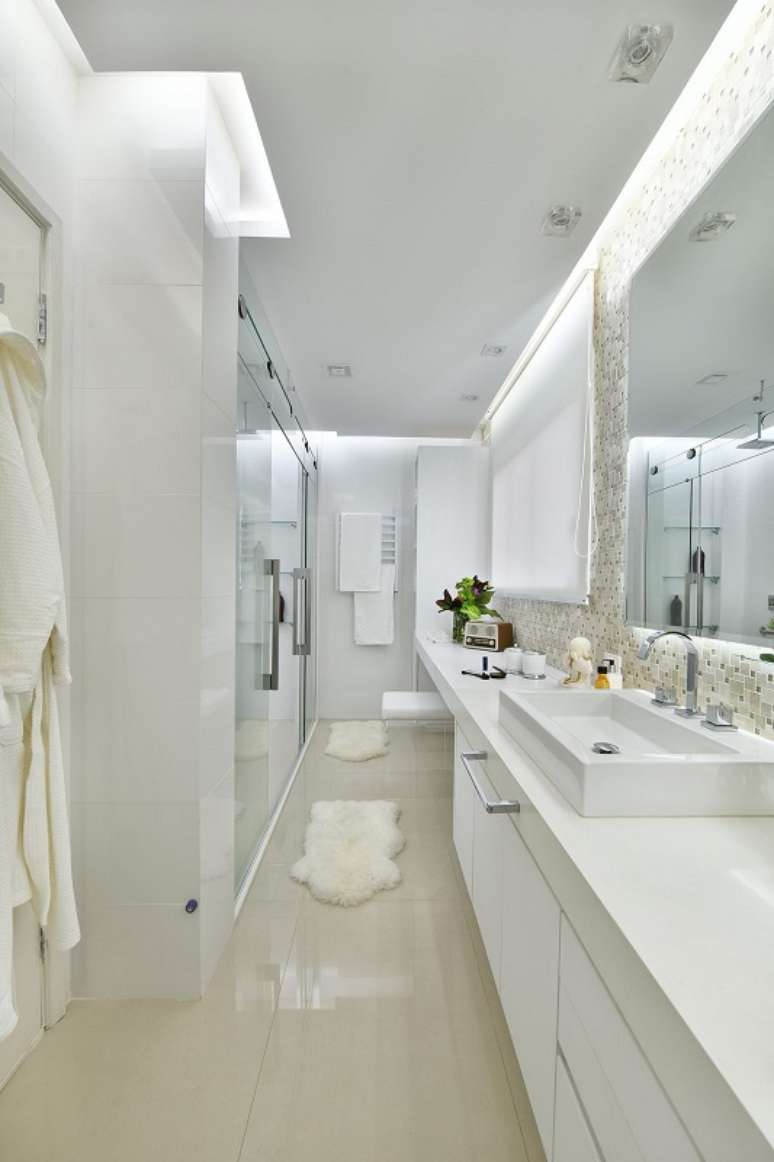 34. A sala de banho tem teto rebaixado para um efeito luminoso e relaxante. Projeto por Tetriz Arquitetura.