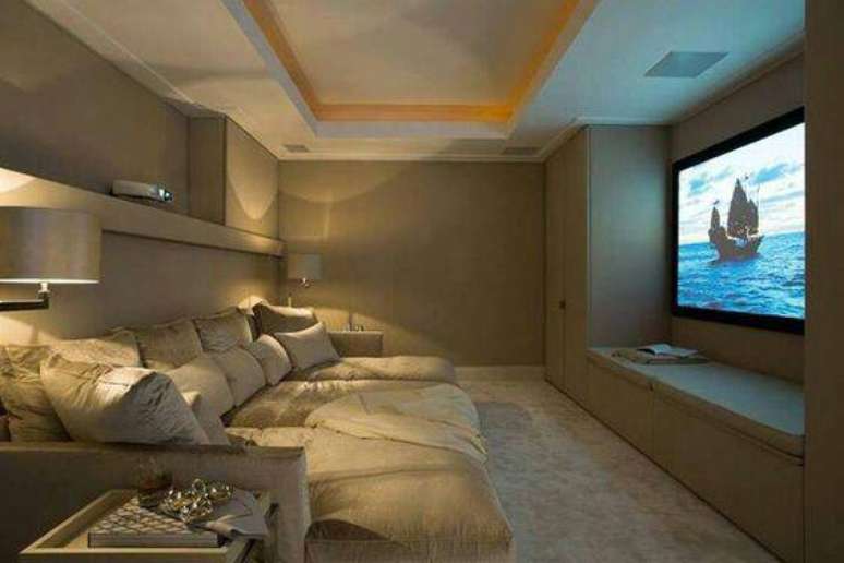 55. Cinema em casa conta com a presença de um sofá retrátil cinza. Fonte: Pinterest