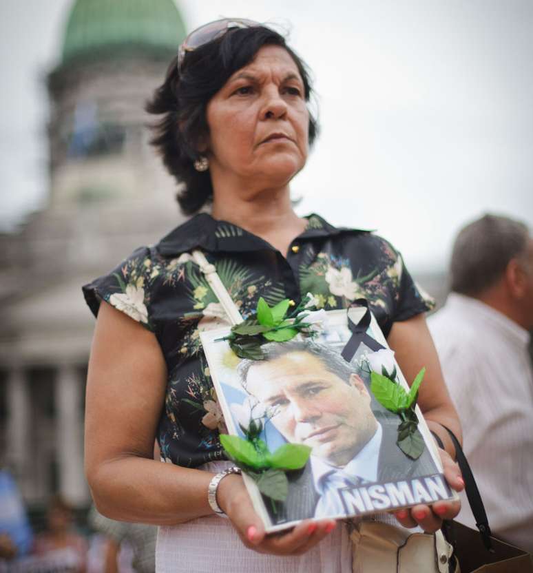 Mulher segura cartaz com o rosto do promotor Alberto Nisman, que investigou atentado na Argentina, mas morreu poucos dias após acusar Cristina