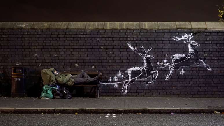 Homem deitado em banco ao lado de grafite de Banksy em Birmingham
09/12/2019
@banksy/Instagram via REUTERS