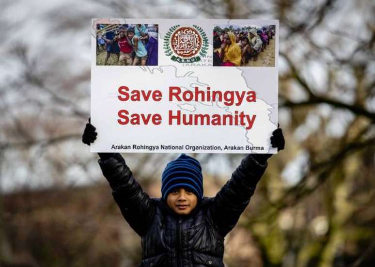 Manifestante levanta cartaz contra matança de rohingyas em Myanmar, em frente à Corte Internacional de Justiça, em Haia