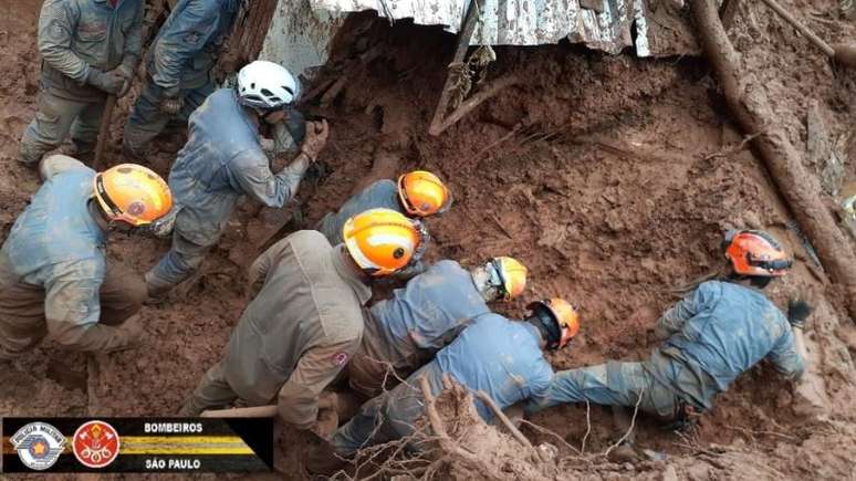 Bombeiros buscam vítimas após deslizamento.