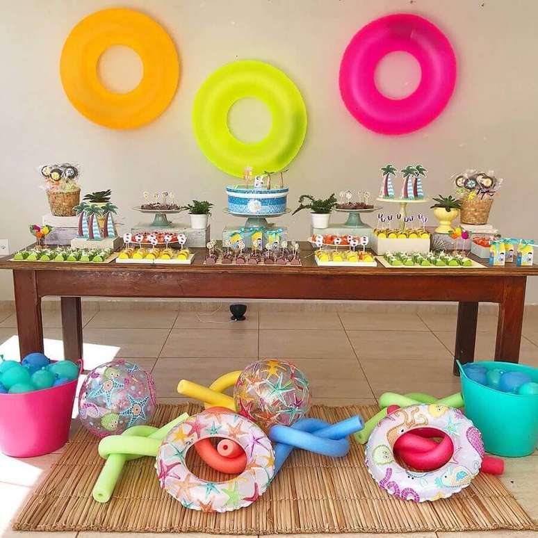 39. Decoração para festa surpresa simples com baias coloridas e mesa cheia de doces – Foto: Thais Amorim