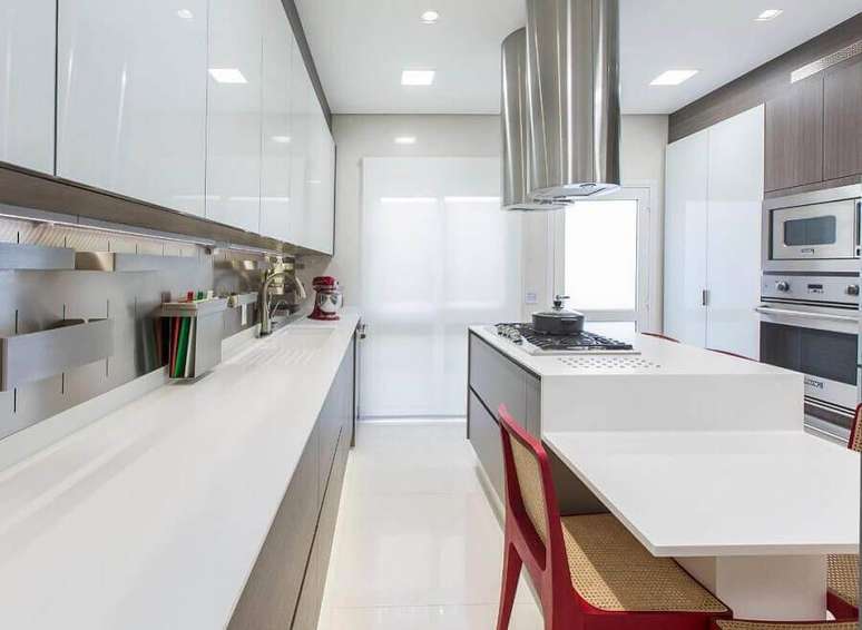 41. Decoração para cozinha planejada com ilha na cor branca e cadeira vermelha – Foto: Rocha e Andrade Arquitetura