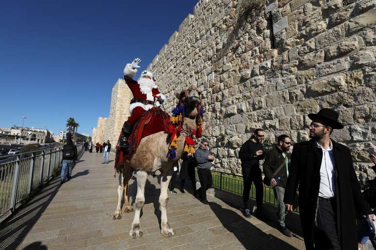Vestido de Papai Noel, Issa Kassissieh usa camelo durante distribui&ccedil;&atilde;o em &aacute;rvores em Jerusal&eacute;m
19/12/2019
REUTERS/Ammar Awad