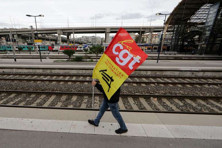 Ferrovi&aacute;rio franc&ecirc;s em greve segura bandeira sindical da CGT enquanto caminha em uma plataforma na esta&ccedil;&atilde;o ferrovi&aacute;ria de Nice durante um dia de greve nacional e protesta contra os planos de reforma das pens&otilde;es do governo franc&ecirc;s
05/12/2019
REUTERS/Eric Gaillard