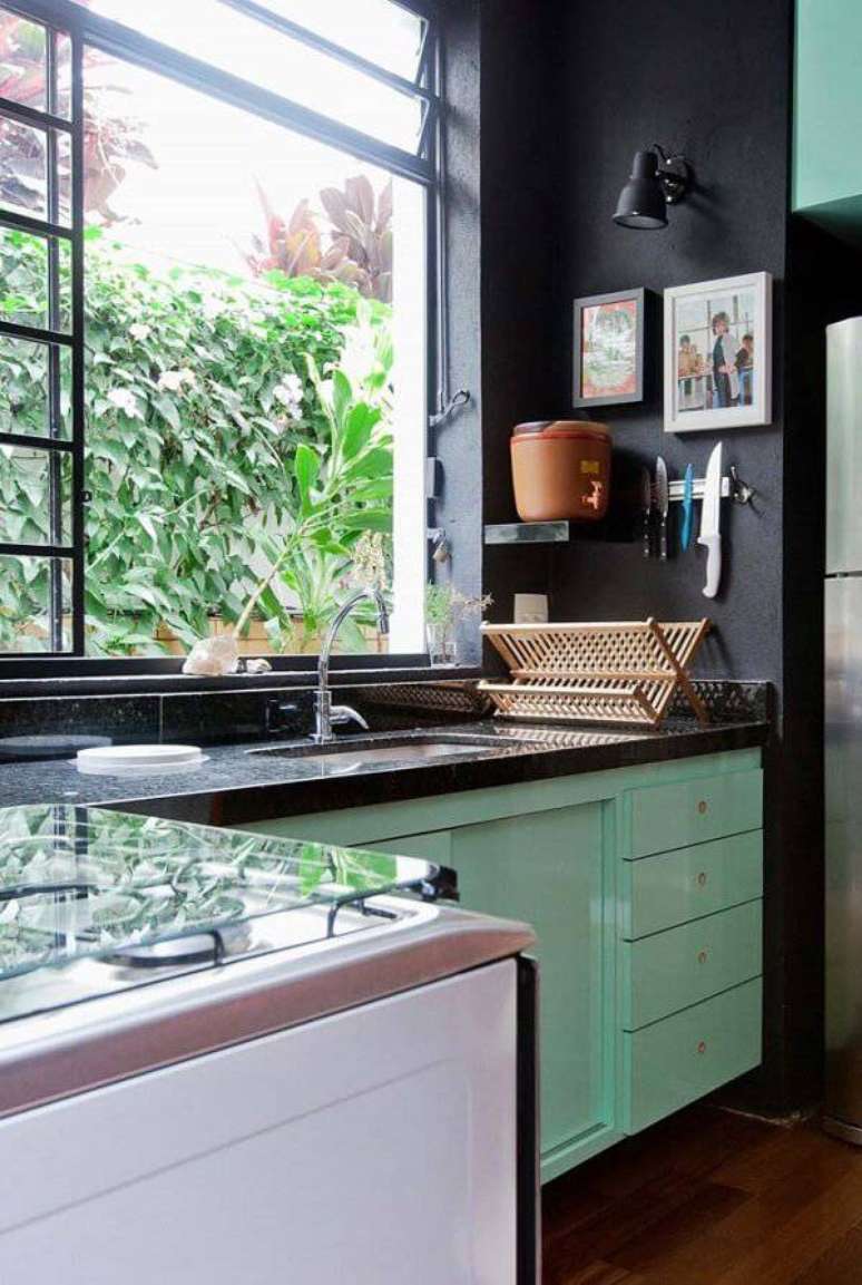 24. Cozinha com decoração descontraída e iluminada com janela grande e bancada de granito verde ubatuba. Fonte: Pinterest