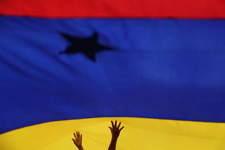 Pessoas seguram bandeira da Venezuela. 14/9/2019. REUTERS/Ivan Alvarado 