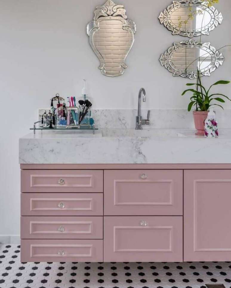 7. Decoração clean para banheiro com bancada de mármore branco e gabinete rosa – Foto: Andrea Murao