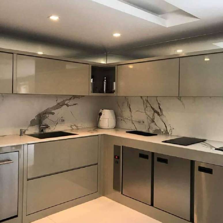 23. Cozinha planejada moderna decorada com armários cinza e mármore branco – Foto: Paola Ribeiro