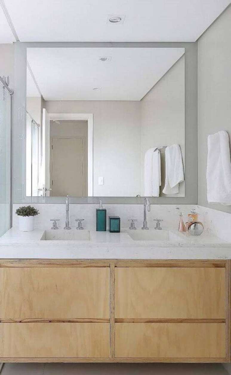 36. Decoração delicada para banheiro com bancada de mármore branco e gabinete de madeira clara – Foto: Behance