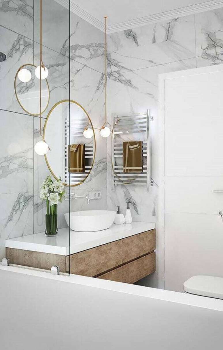 38. Banheiro moderno e minimalista decorado com paredes de mármore branco Carrara e detalhes dourados para um toque sofisticado – Foto: Transforme sua Casa