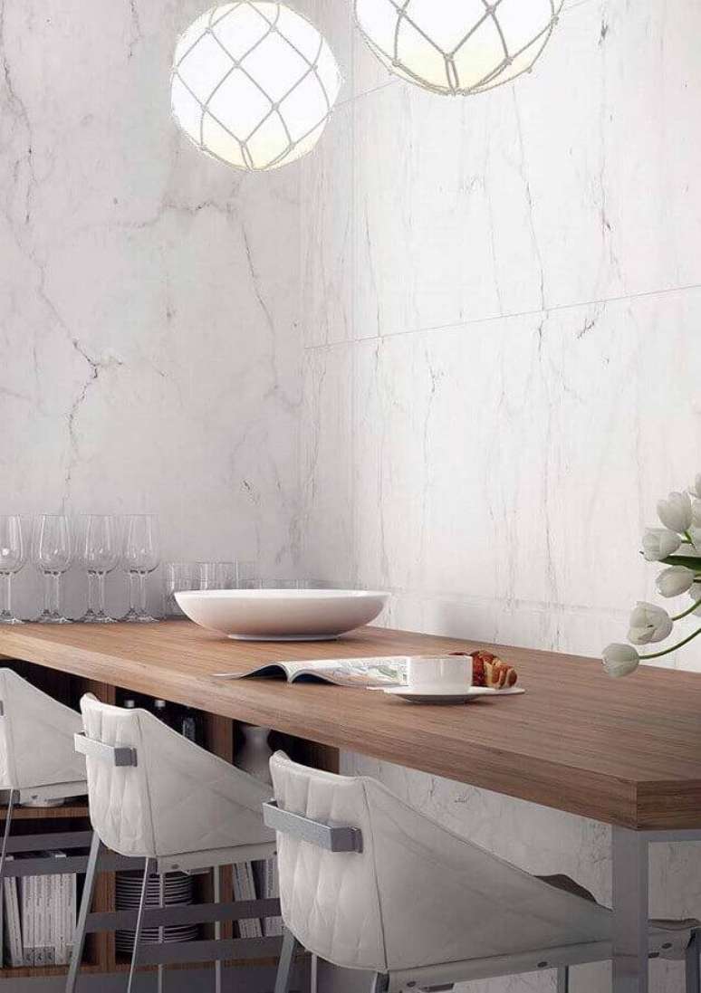 55. Paredes com revestimentos de pedra de mármore branca e mesa de madeira – Foto: Maurício Gebara Arquitetura
