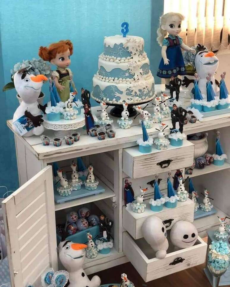31. Decoração de aniversário com bolo da Frozen branco e azul 3 andares – Foto: Très Jolie Festas