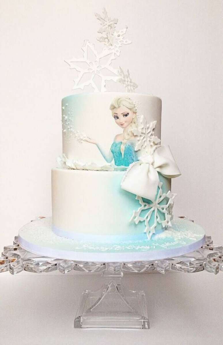 32. Decoração de bolo da Frozen com desenho da Elsa e flocos de neve no topo – Foto: A Minha Festinha