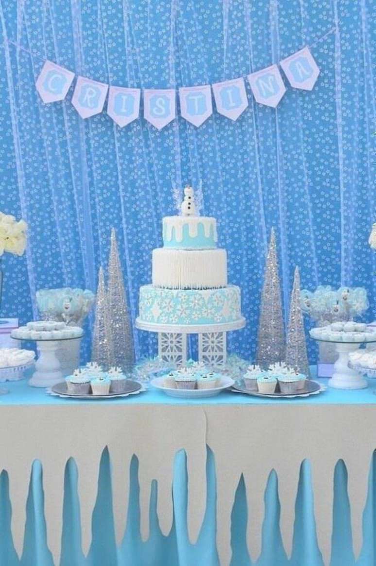 51. Mesa de aniversário azul e branca decorada com bolo da Frozen 3 andares com pequeno Olaf no topo – Foto: Assetproject