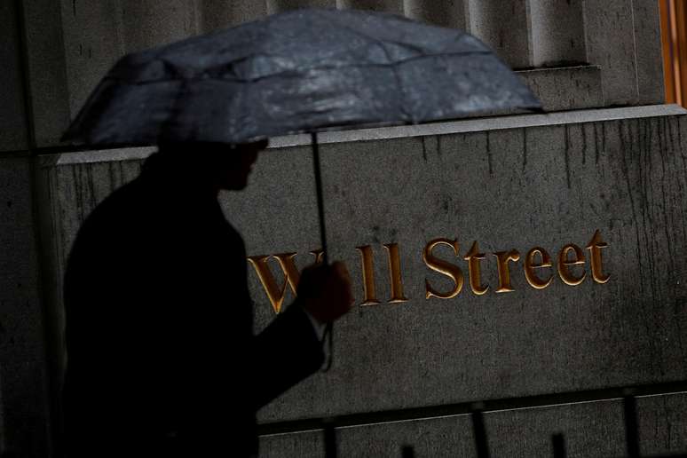 Homem caminha pela chuva em Wall Street do lado de fora da Bolsa de Nova York (NYSE), EUA. 09/10/2019. REUTERS/Brendan McDermid