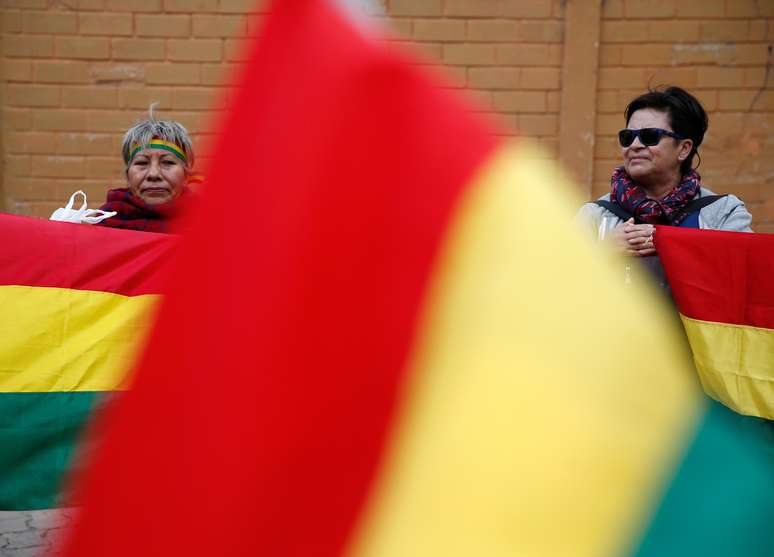 Mulherres são vistas entre bandeiras da Bolívia. 28/12/2019. REUTERS/David Mercado 