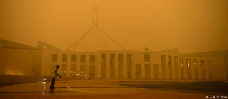 Faxineiro limpa pátio do Parlamento em Camberra: ar da capital australiana é afetado por queimadas
