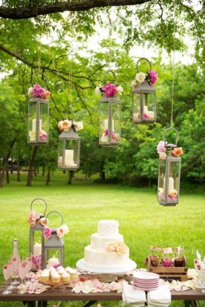 12. Detalhes românticos com flores e velas para decoração de aniversário de casamento ao ar livre – Foto: Papo Glamour