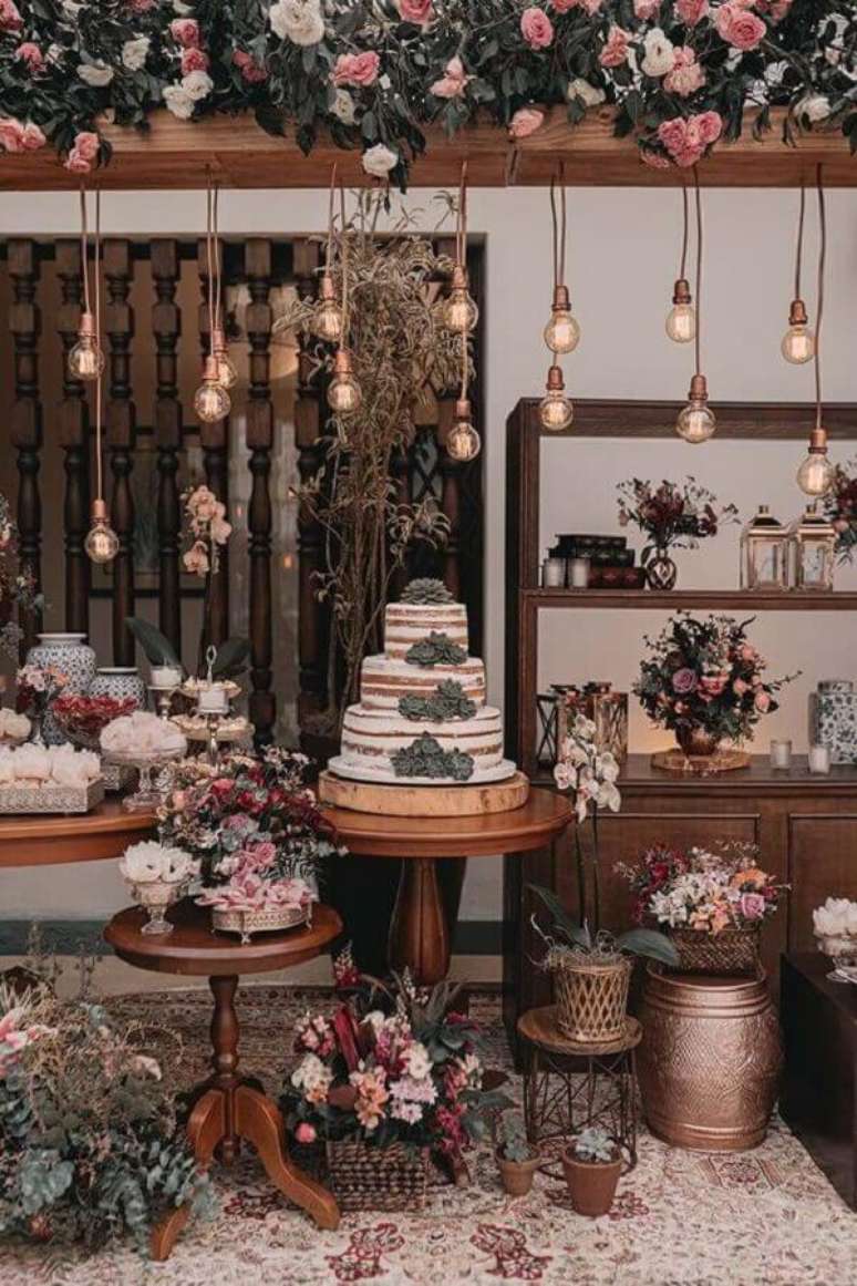 41. Decoração rústica para festa de aniversário de casamento com luminárias e arranjo de flores – Foto: iCasei