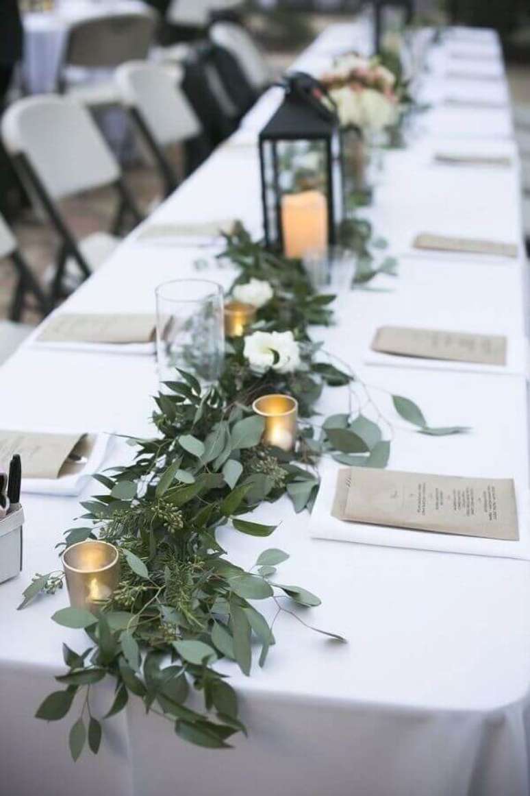 56. Mesa de aniversário de casamento decorada com folhagens e velas – Foto: Pinterest