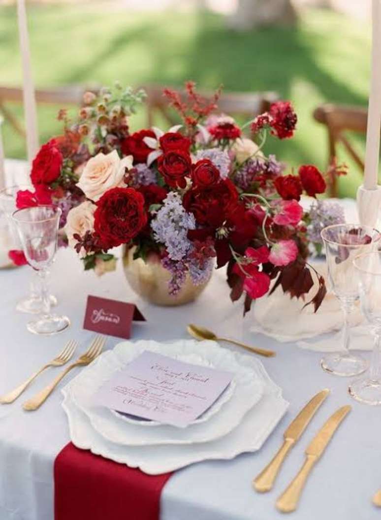 42. Flores vermelhas na decoração da mesa de jantar e enfeites dourados – Via: Elle Decor