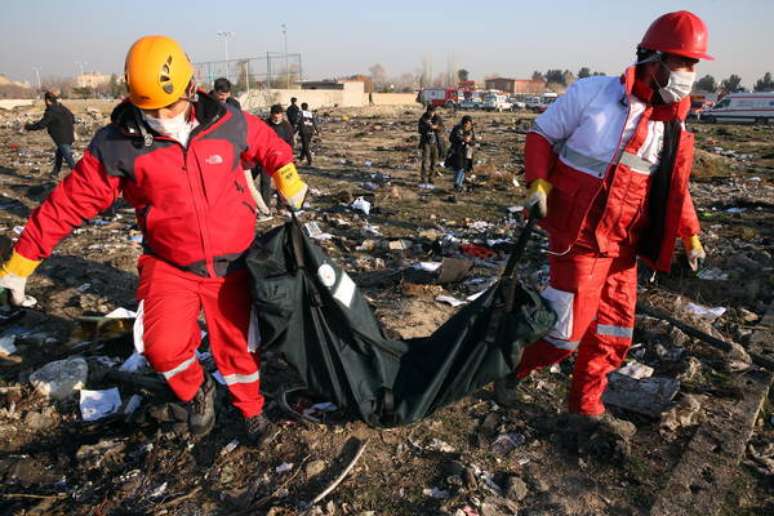 Membros do Crescente Vermelho recolhem corpos de acidente aéreo em Teerã