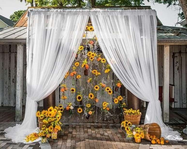 77. Decoração externa com cortina e flores para festa tema girassol. Fonte: Pinterest