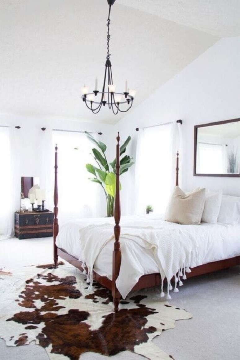 27. Quarto de casal decorado com cama de madeira e tapete de couro de boi – Foto: Apartment Therapy