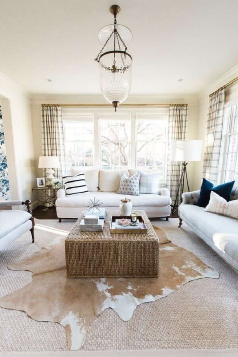 29. Decoração em tons neutros com sofá branco e tapete de couro para sala – Foto: Studio McGee