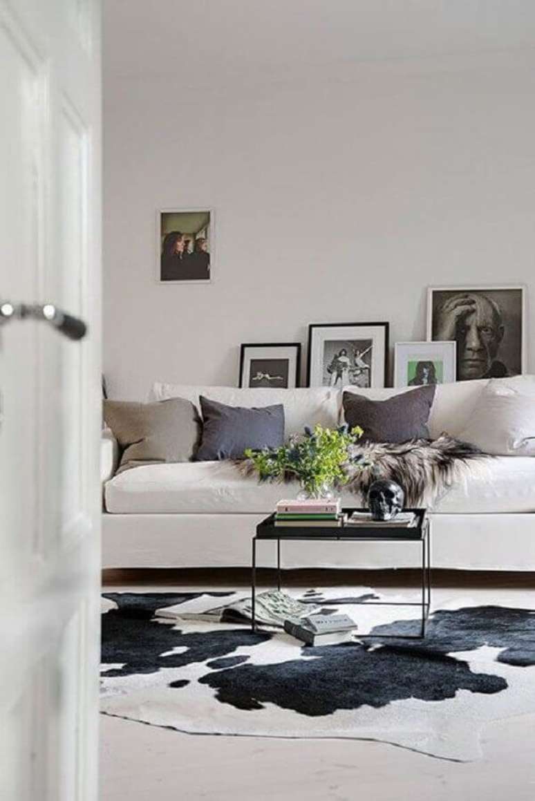36. Sala decorada com tapete de couro de boi e sofá branca – Foto: Tudo Especial