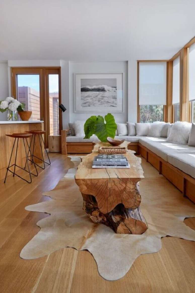 40. Sala decorada com móveis de madeira e tapete de couro bege – Foto: Architectural Digest