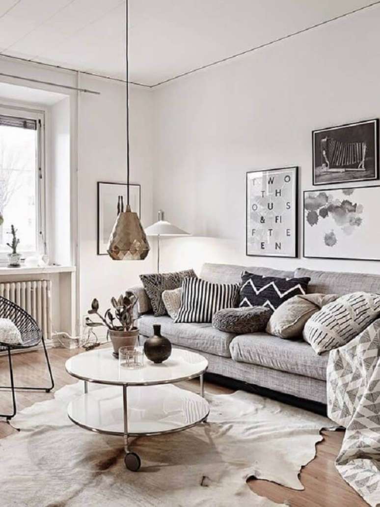 42. Tapete de couro bege para sala decorada com várias almofadas e quadros – Foto: Pinterest