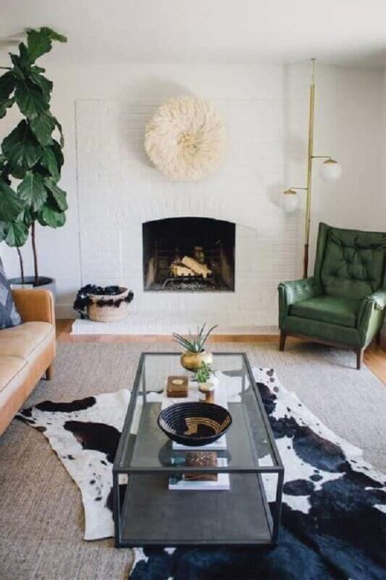 57. Tapete de couro para sala decorada com lareira e poltrona verde – Foto: Zeal Living