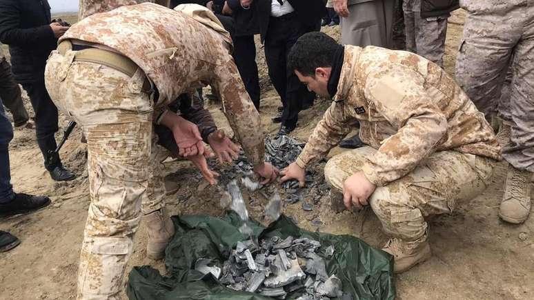 Agentes de segurança recolhem detritos de cratera em Bardah Rashsh