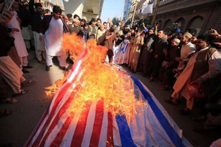 Manifestantes em Peshawar, Paquistão, queimam bandeiras de EUA e Israel em protesto contra ataque que matou o general Qassem Soleimani