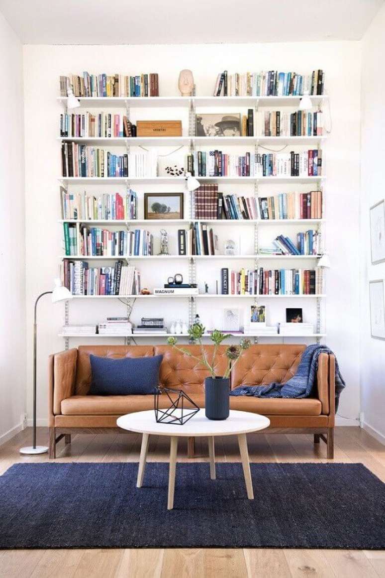 35. Decoração simples para sala com estante de livros e sofá marrom – Foto: Architonic