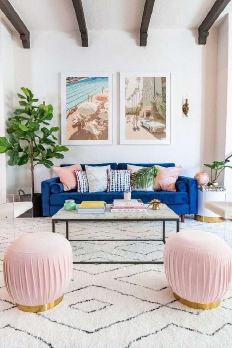 47. Sala de estar clean decorada com sofá de veludo azul e puffs redondos cor de rosa – Foto: Joss & Main