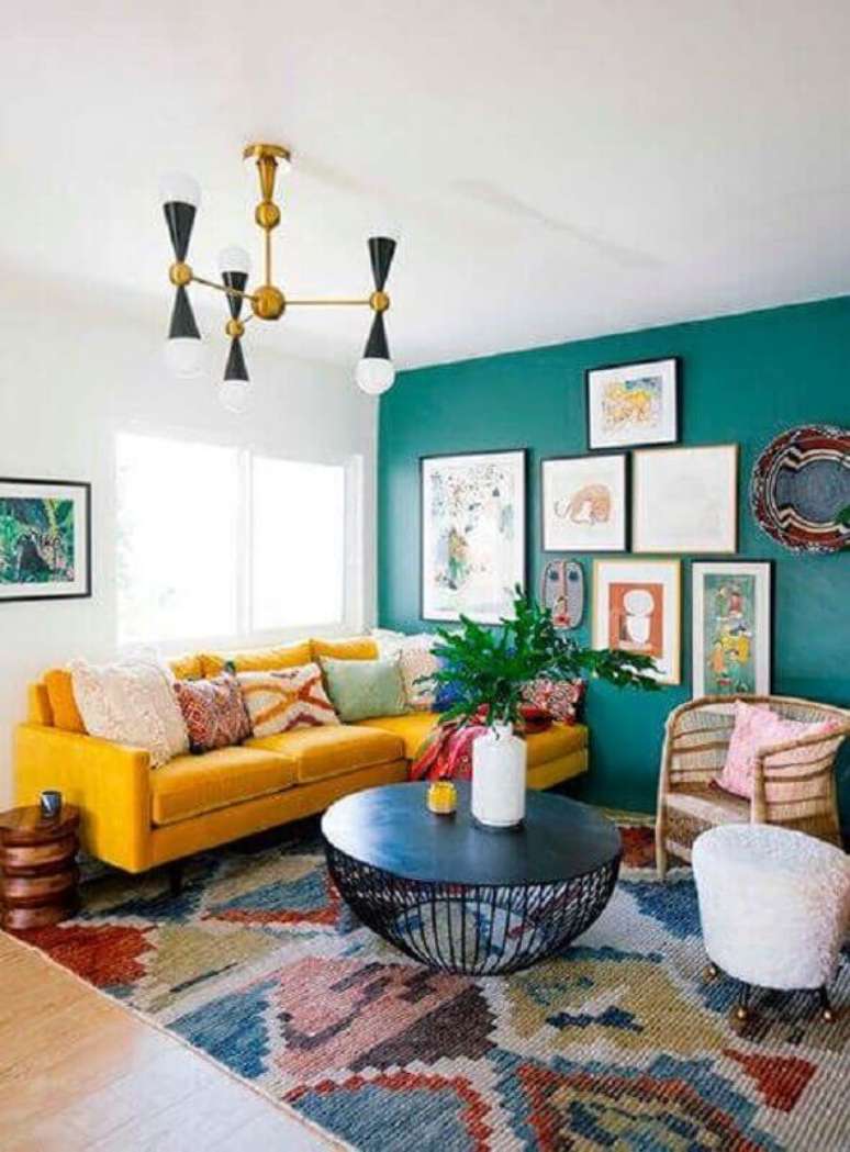 77. Sala colorida decorada com sofá com chaise amarelo e parede verde com vários quadros – Foto: Archilovers