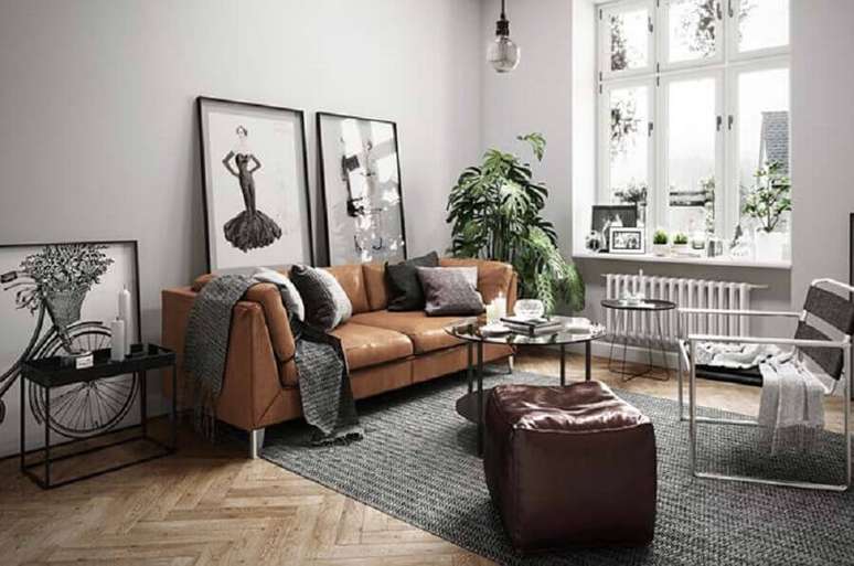 86. Sofá de couro marrom para decoração de sala cinza com quadros grandes – Foto: Behance
